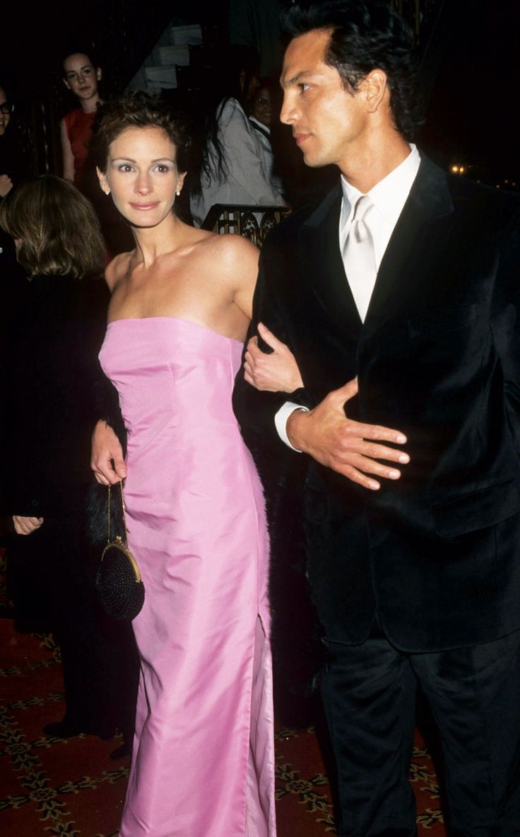 a man in a tuxedo standing next to a woman in a pink dress