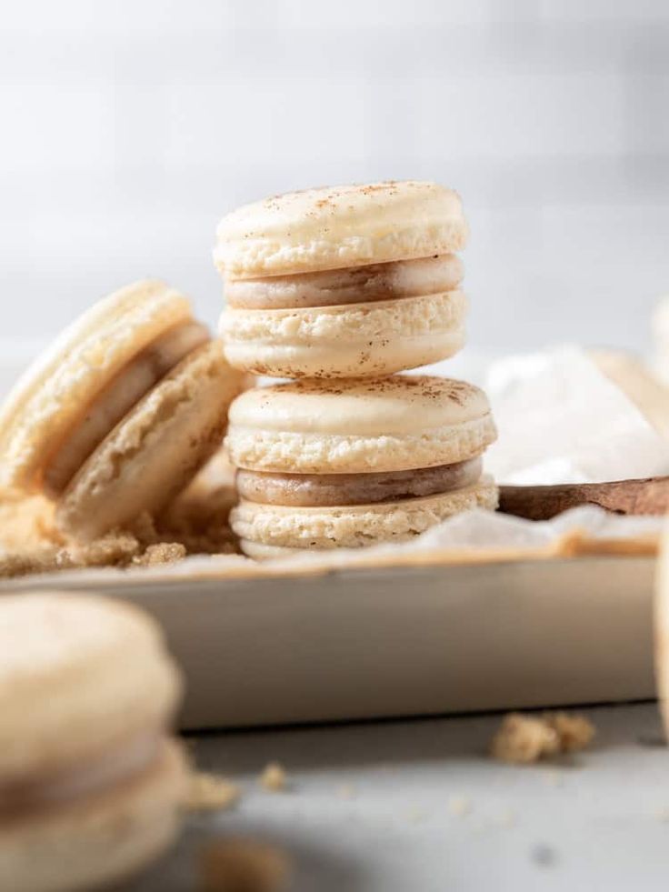 a stack of three macaroons sitting on top of each other next to some cookies