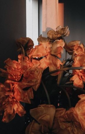 a vase filled with lots of orange flowers next to a window sill on a sunny day