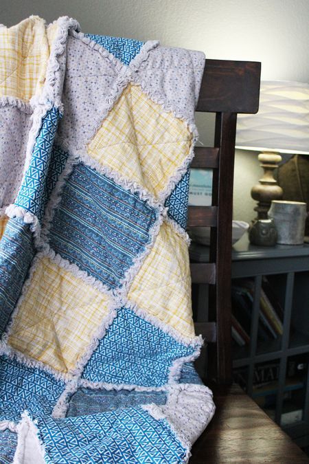 a blue and yellow blanket sitting on top of a wooden chair