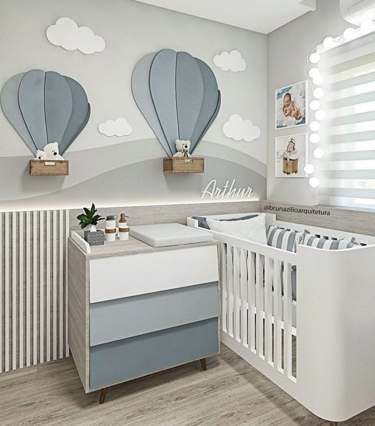 a baby's room with two hot air balloons on the wall and a crib