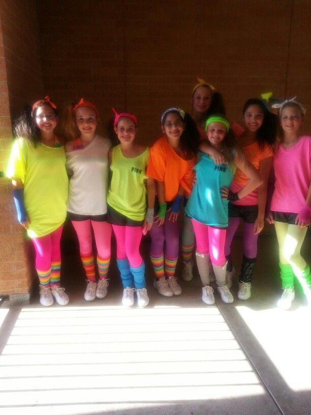 a group of young women standing next to each other wearing neon colored clothing and headbands