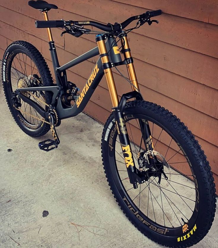 a mountain bike parked in front of a brown building with black and gold trimmings