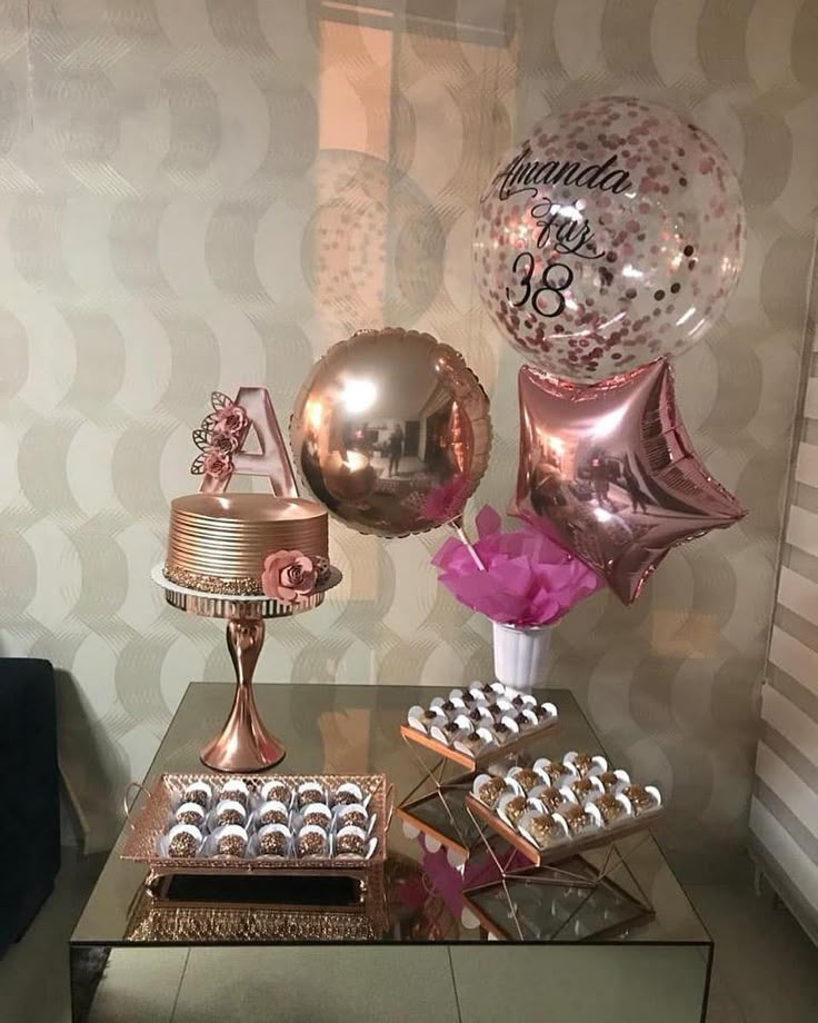 a table topped with lots of balloons and cake