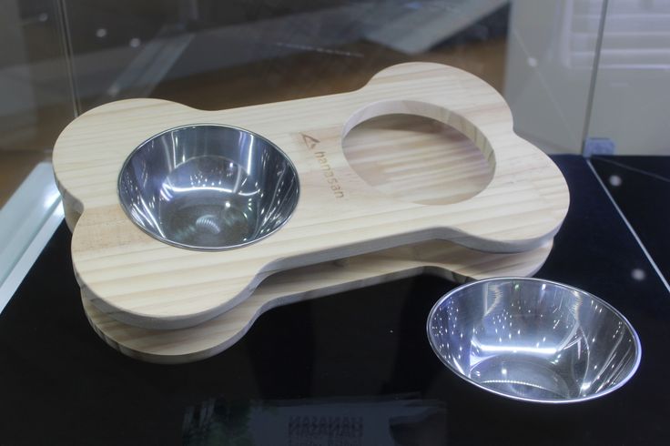 a wooden dog bowl holder with two bowls on it