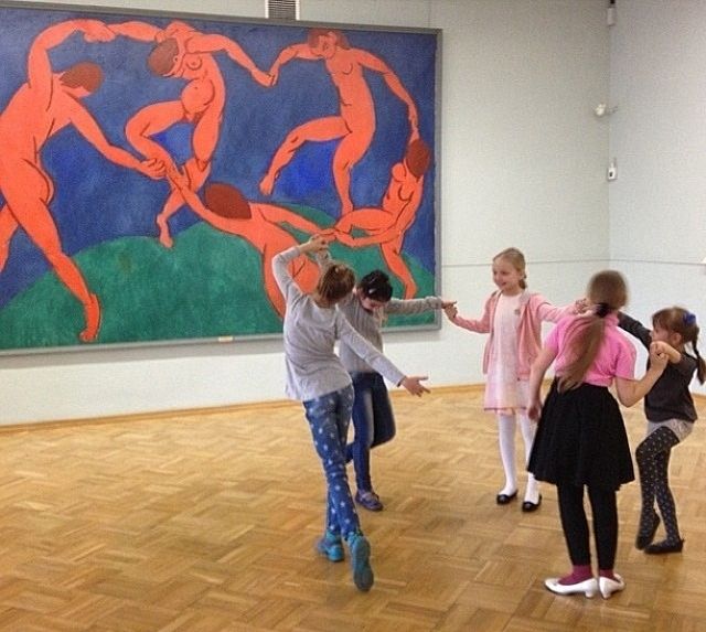 several children are dancing in an art gallery