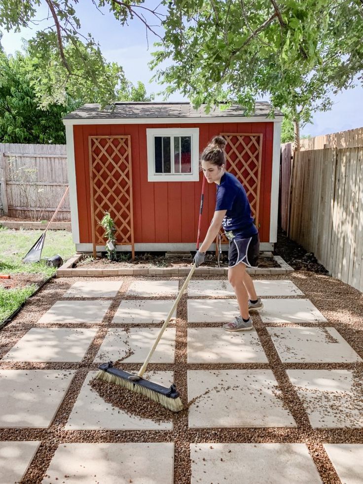 a young boy is cleaning the yard with a mop