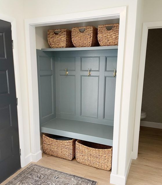 an entryway with baskets on the shelves