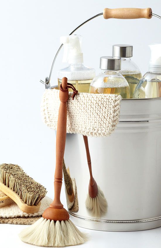 a white bucket filled with lots of different types of cleaning products next to a brush