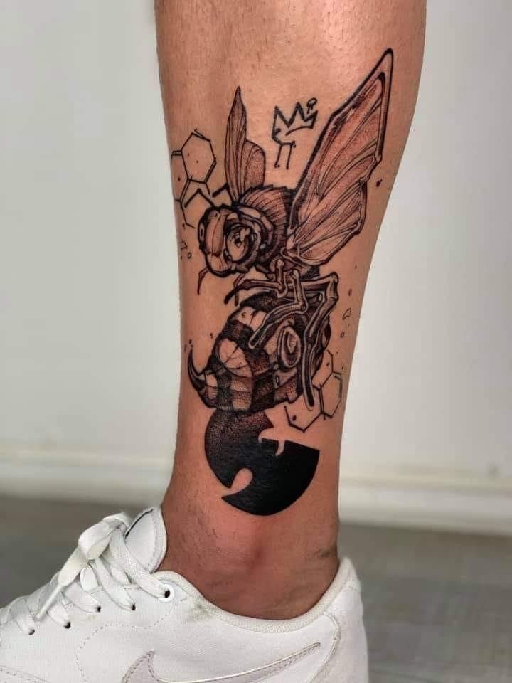 a tattoo on the leg of a man with a bee in it's head