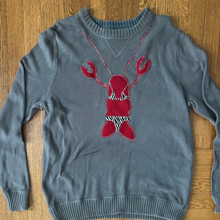 a blue sweater with a red lobster on it