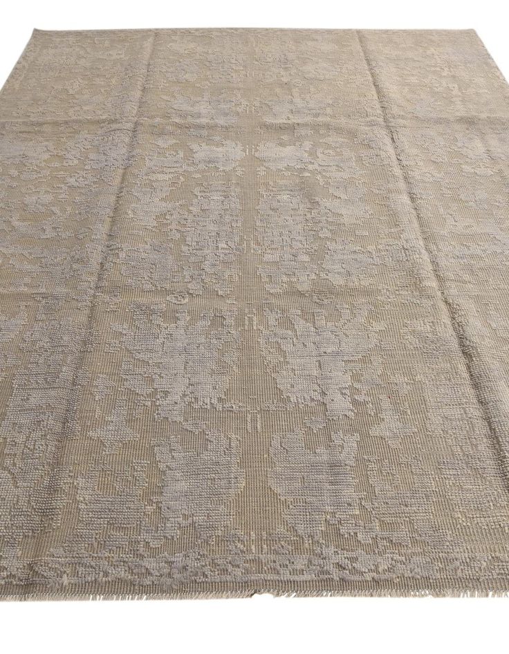 a large rug with an intricate design on the top and bottom, in beige tones