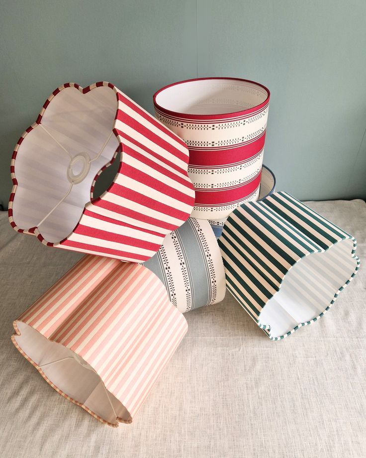 four striped paper cups are stacked on top of each other, and one is empty