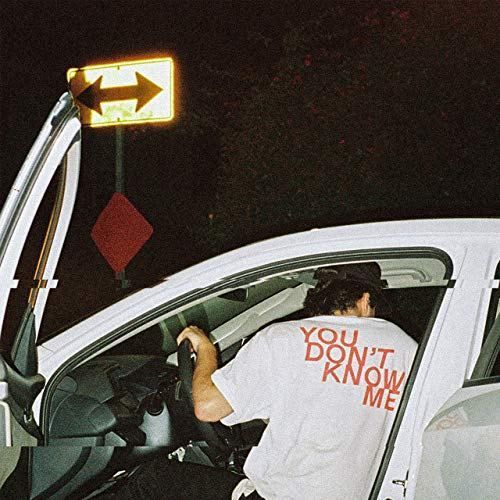 a man sitting in the driver's seat of a car with his back door open