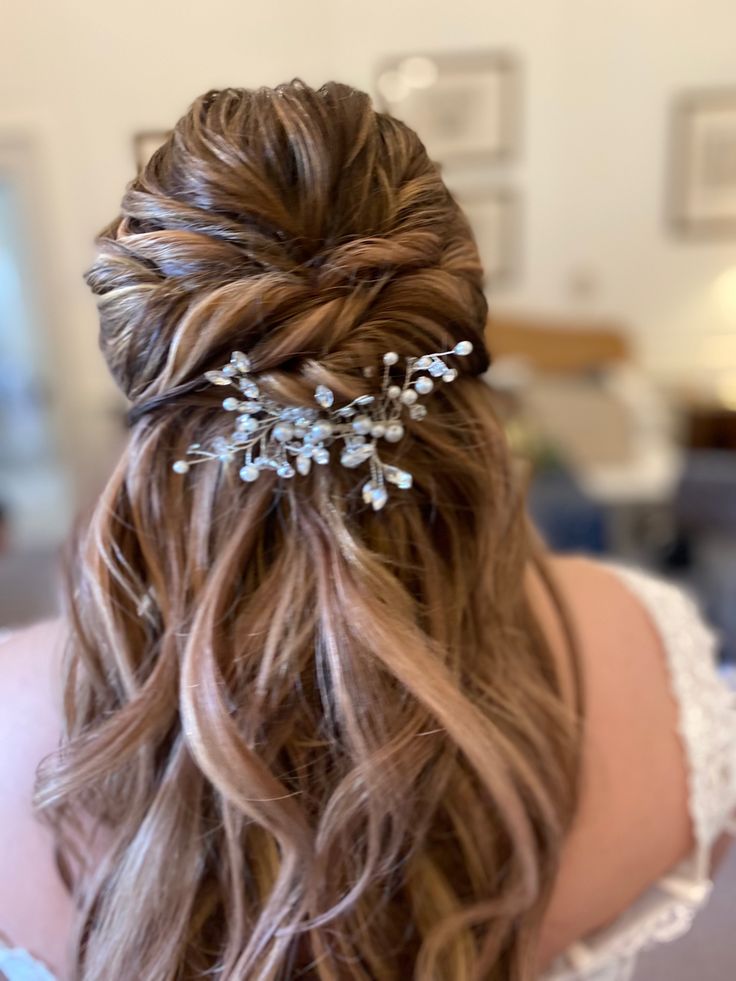 the back of a woman's head with long hair and flowers in her hair