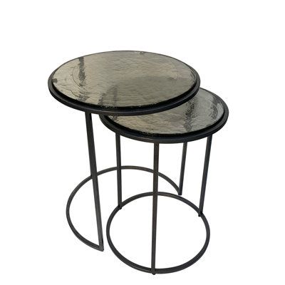 two black metal and glass side tables with circular bases, one on each end table