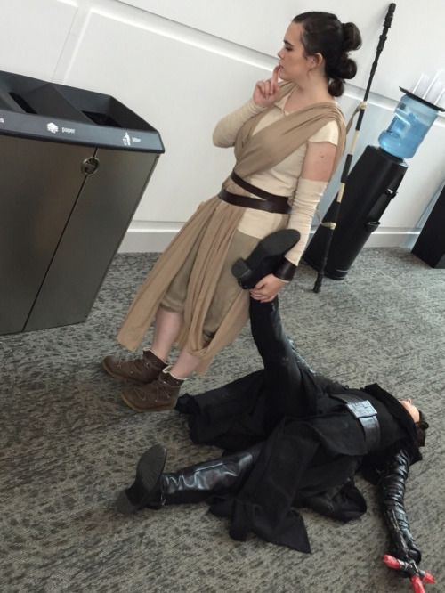 two people dressed as star wars characters, one on the floor and one on the ground