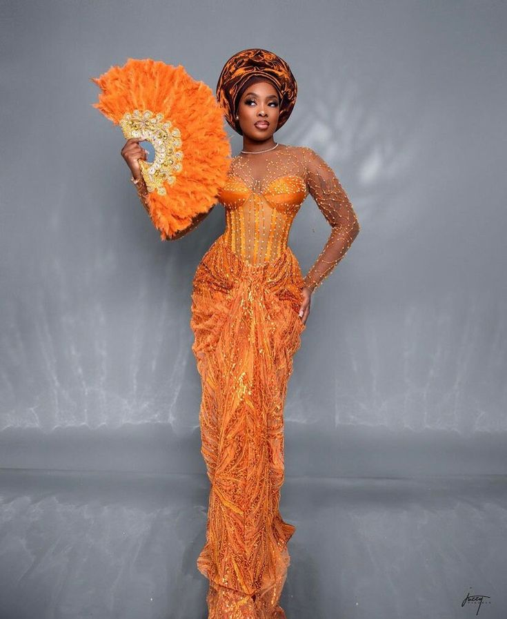 Become a showstopper in this stunning number!  Hand fan and head gear (gele) sold differently.  Please note that custom/luxury dresses cannot be returned or exchanged. All sales are final! ‼️MEASUREMENTS REQUIRED ‼️ Burst Hips  Waist Dress length  Sleeve length  Under burst Shoulder  Please note that the exact fabric might not be available and we will provide similar options  Made with 100% lace Care: Hand wash. Do not bleach Feel free to start a chat for any enquiry. Thanks for visiting. Luxury Red Sets For Traditional Ceremonies, Traditional Laos Wedding Dress, Yellow Ball Gown For Wedding, Orange Floor-length Evening Dress For Wedding, Fitted Orange Evening Dress For Wedding, Orange Fitted Wedding Gown, Fitted Orange Wedding Gown, Traditional Orange Wedding Dress, African Bride Dress