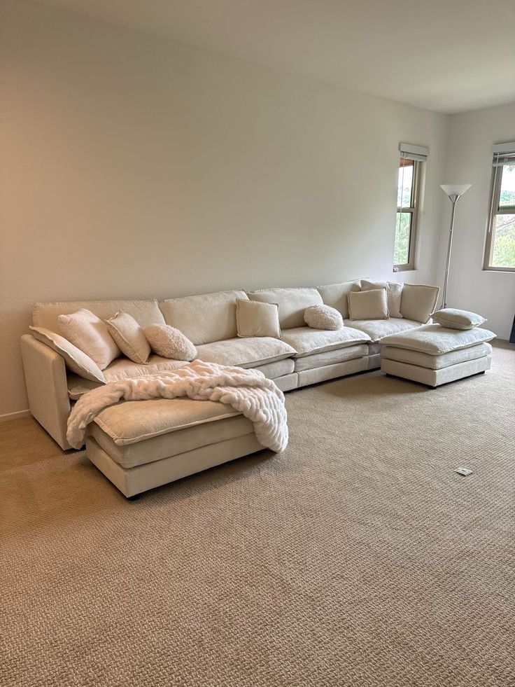 an empty living room with a large sectional couch