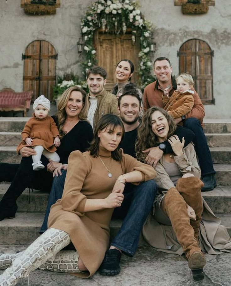 a group of people sitting on the steps in front of a building