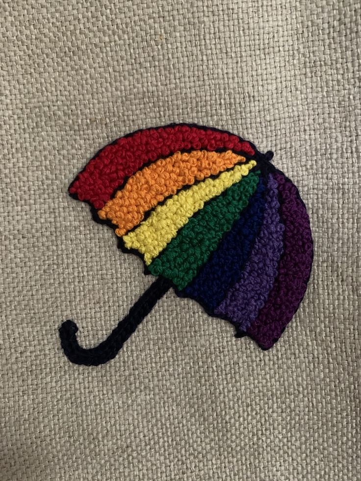 a multicolored crocheted umbrella on a white sweater