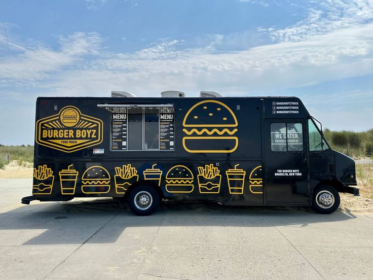 a black food truck with yellow graphics on the side