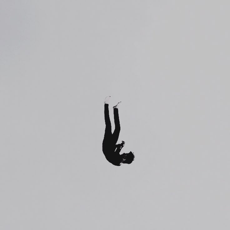 a person is in the air with their feet up and holding onto an object that appears to be upside down