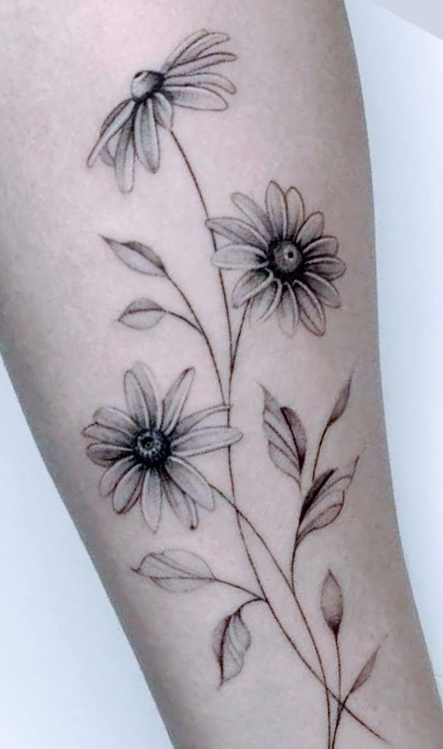 a black and white flower tattoo on the leg