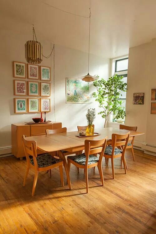 a table and chairs in a room with pictures on the wall