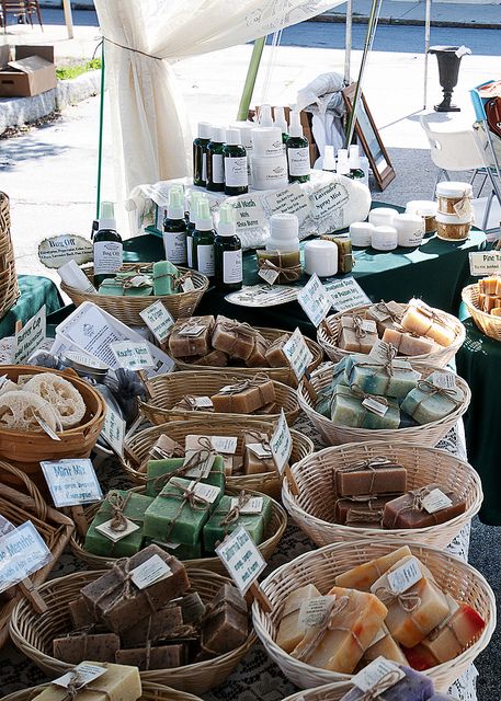 several baskets full of soaps and other items on display at an outdoor market stall