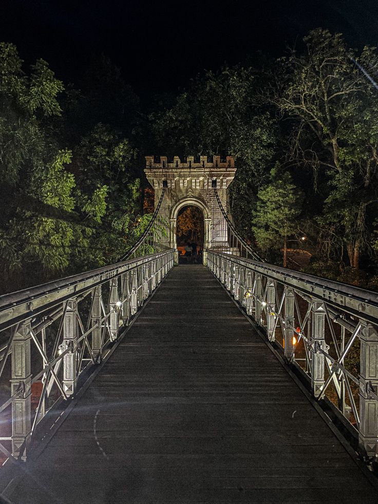 the bridge is lit up at night and there are no cars on it or people