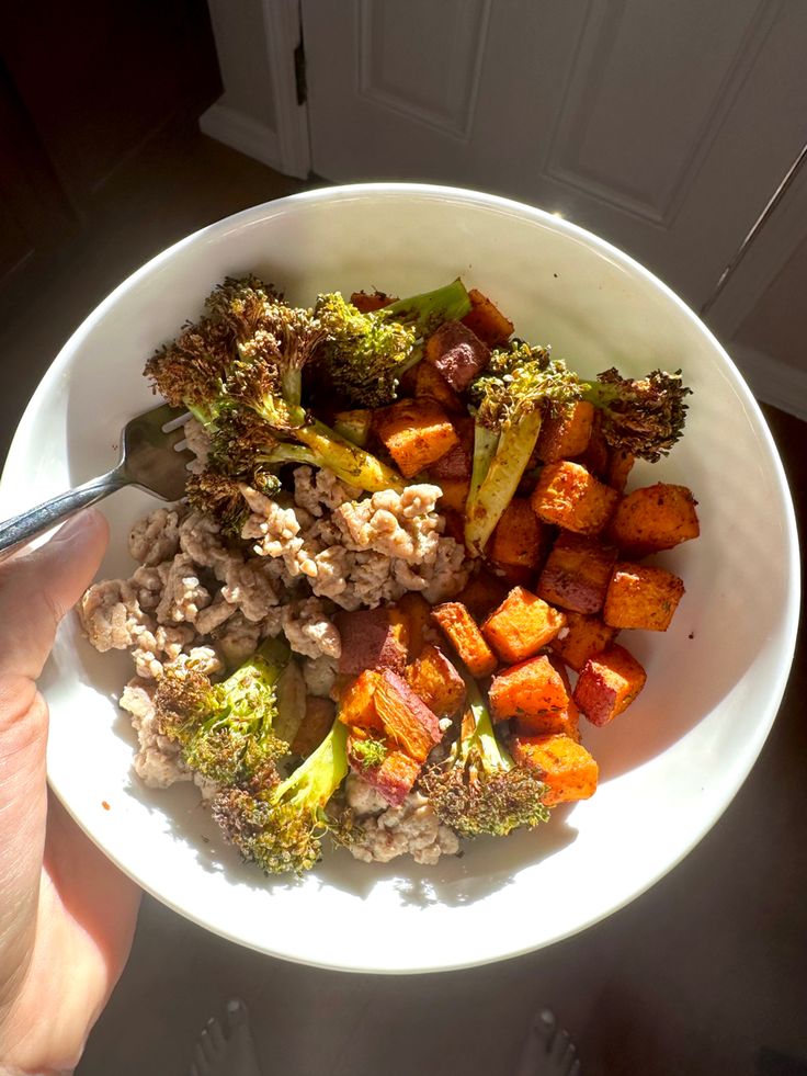 a white bowl filled with vegetables and meat