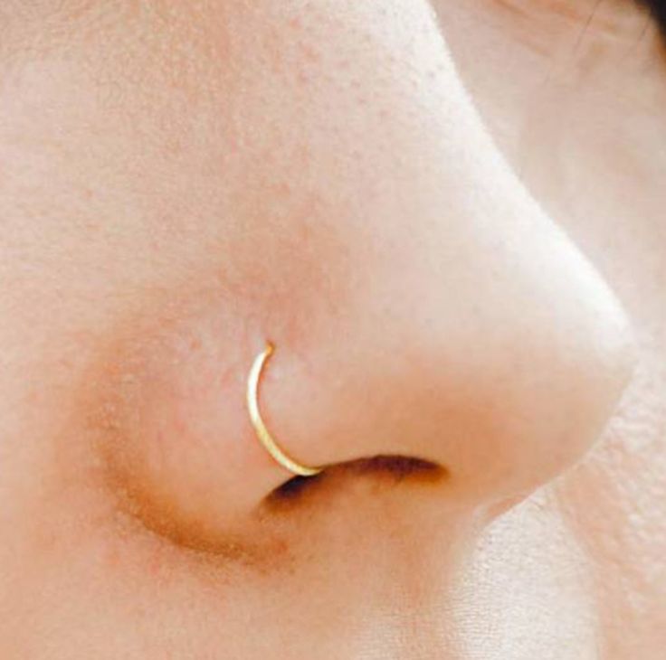 a close up view of a nose with a gold nose ring