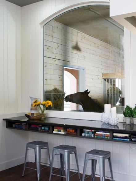 two stools sit in front of a mirror on the wall next to a bar