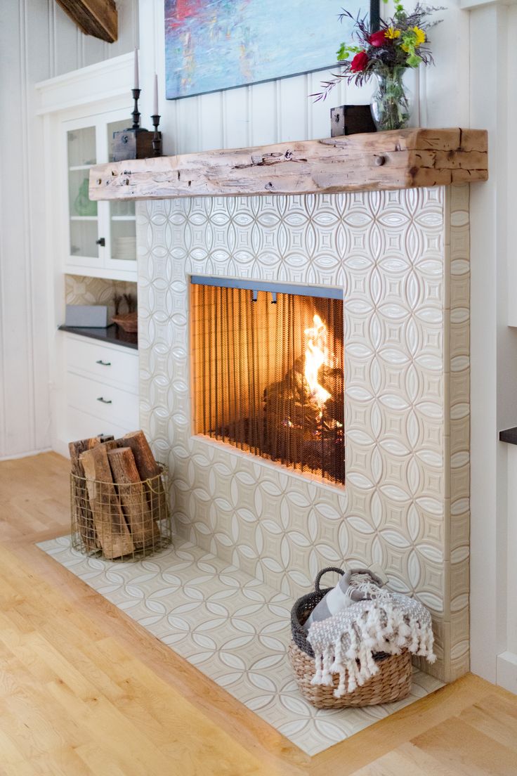 a fire place in the middle of a room with wood flooring and white walls