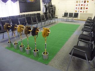 the chairs are lined up in rows with fake animals sticking out of them'heads