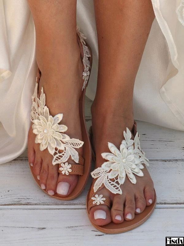 the bride's feet are adorned with white lace and flowers, along with her wedding dress