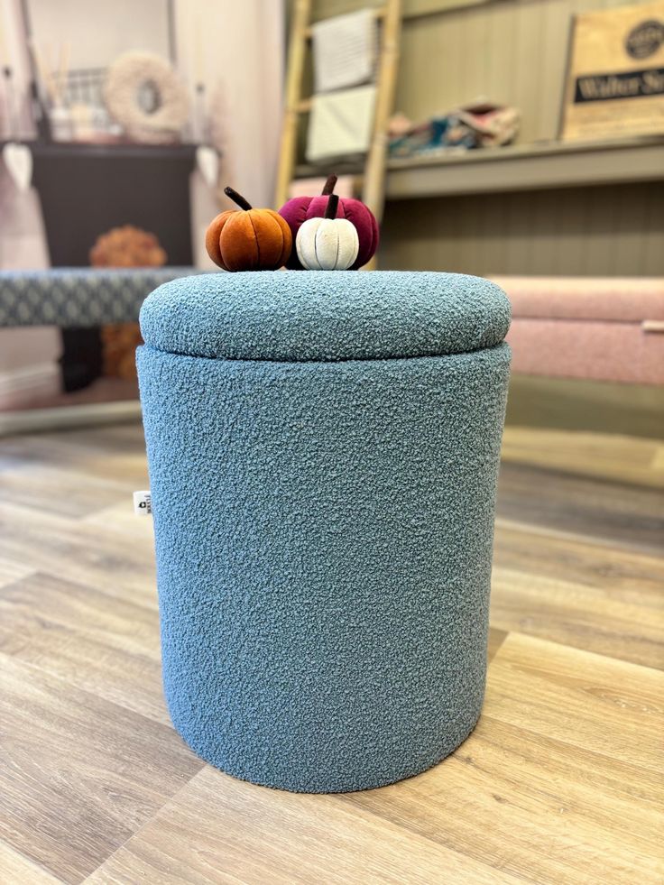 a blue ottoman sitting on top of a wooden floor