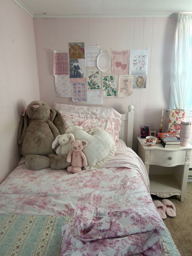 two teddy bears sitting on top of a bed in a room with pink walls and carpet