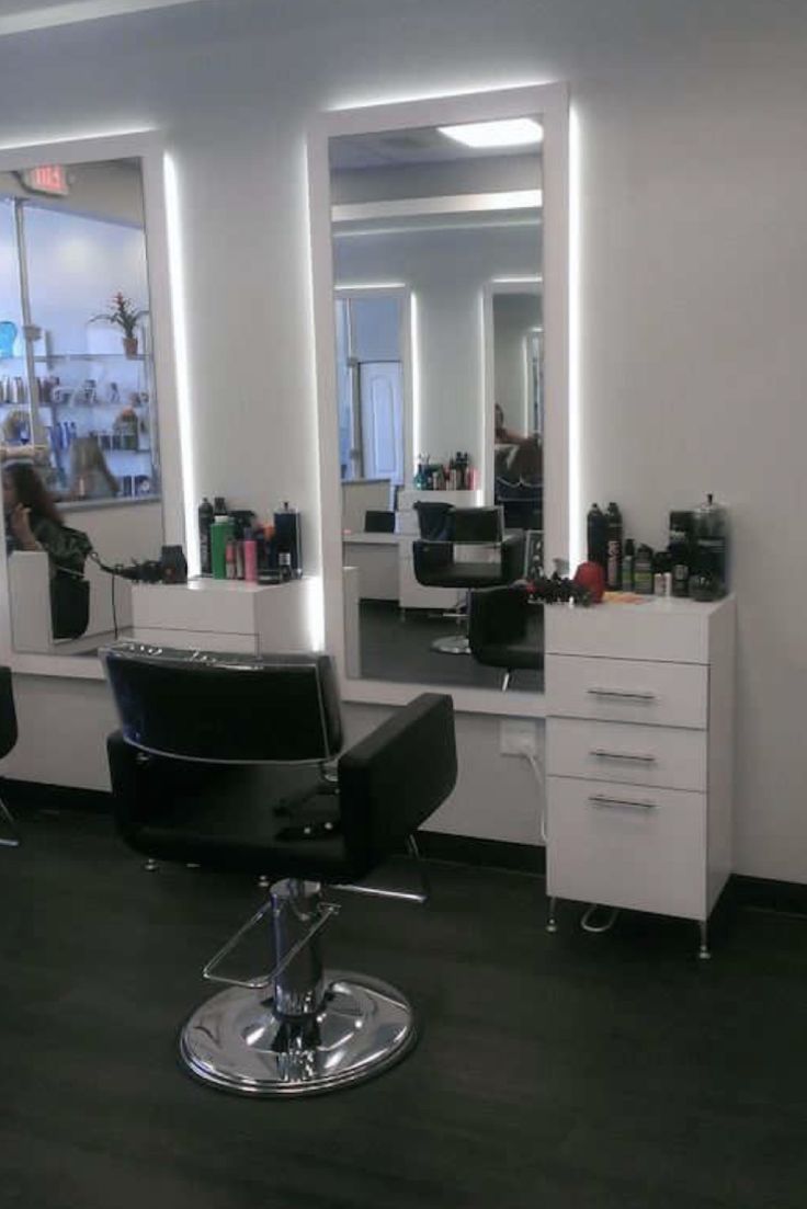 a hair salon with black chairs and mirrors