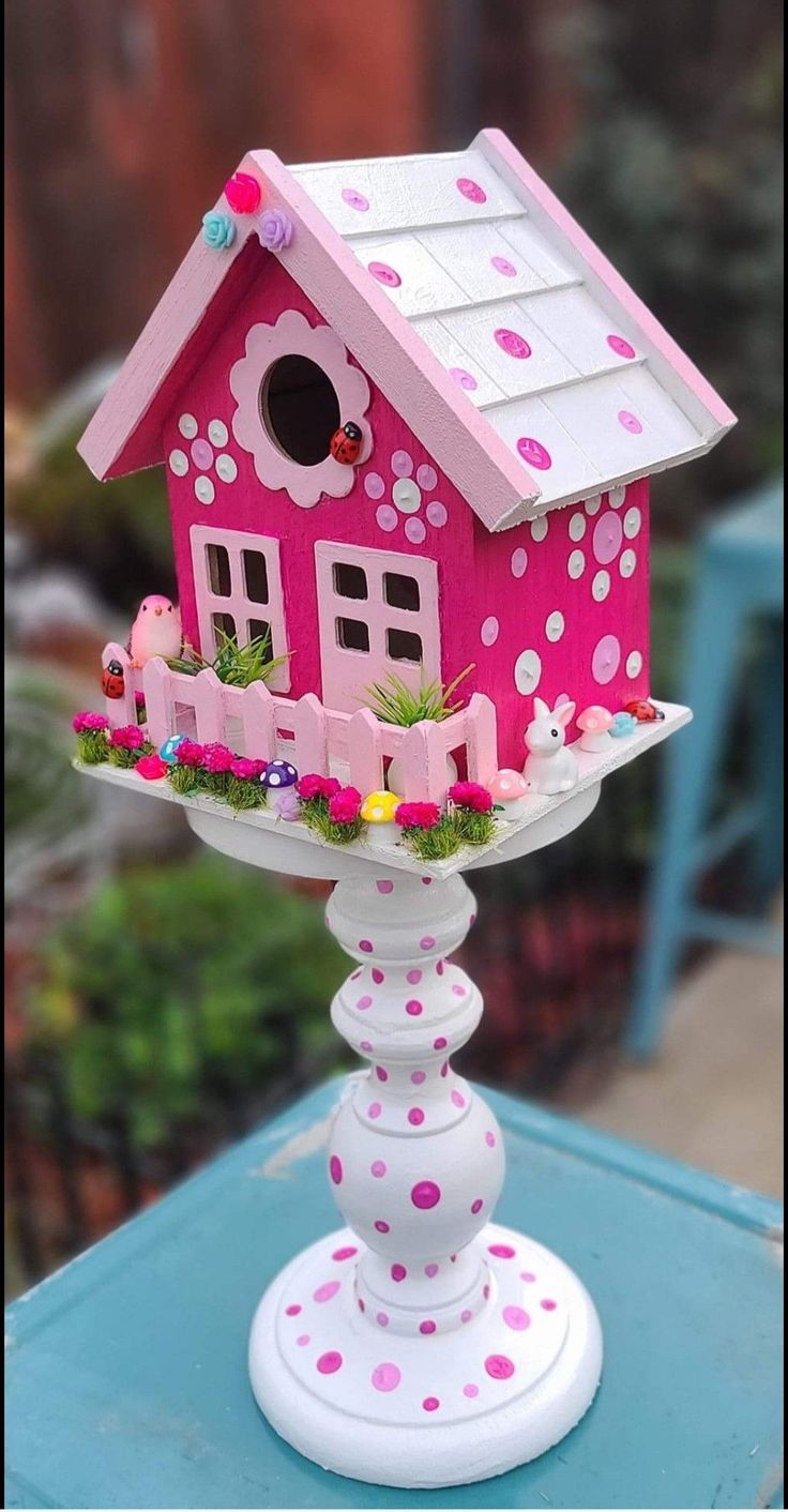 a pink birdhouse with polka dots on it