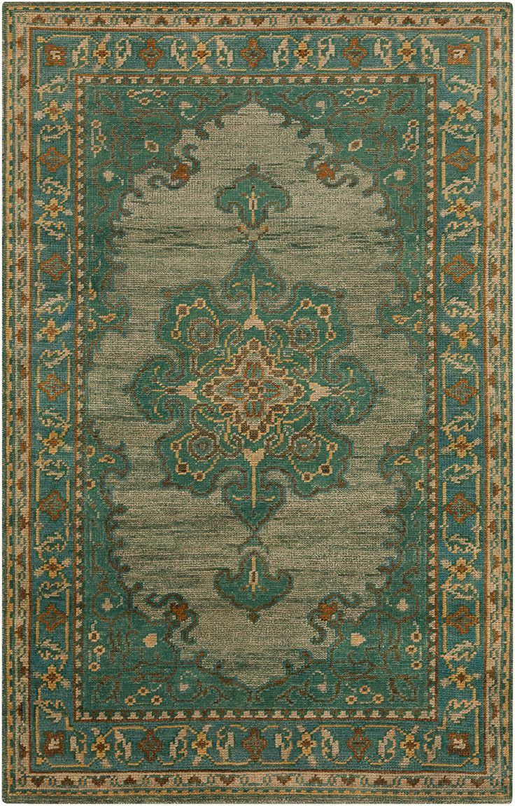 a green rug with an ornate design on the bottom and sides, in various colors