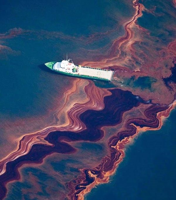 a large boat floating on top of a lake covered in brown and green algaes