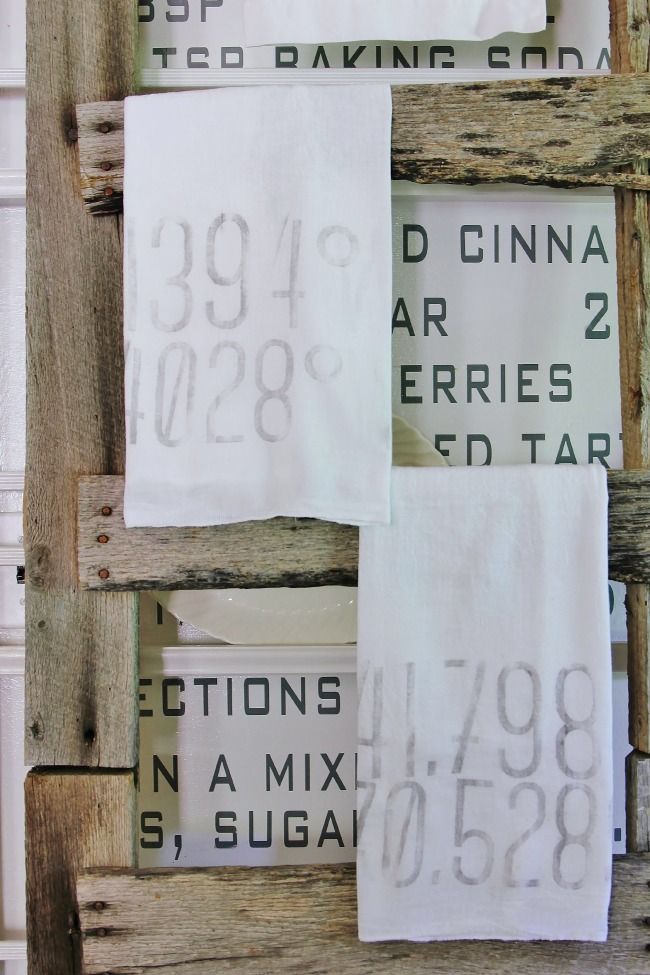 some white towels are hanging up on a wooden rack with numbers and times printed on them