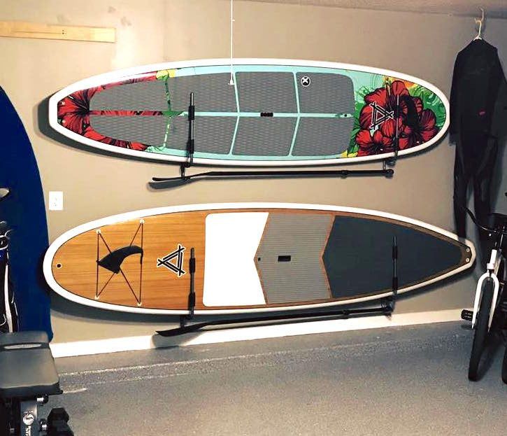 two surfboards are hanging on the wall in a room with other items and equipment