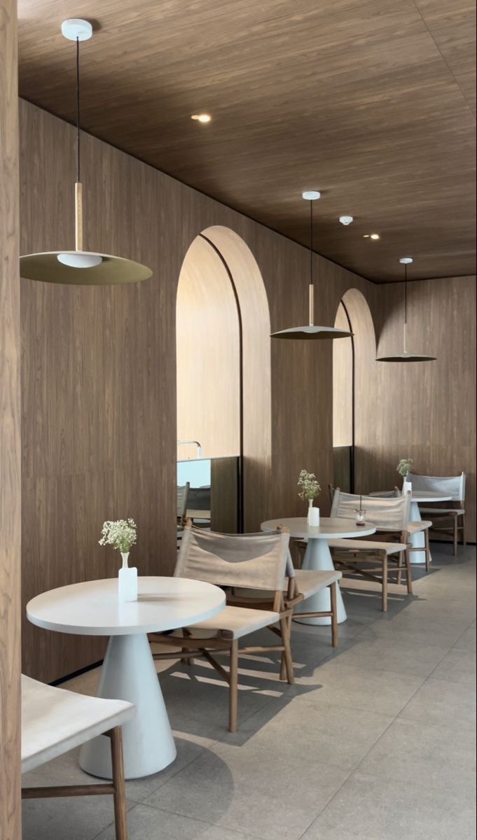 an empty restaurant with white tables and chairs