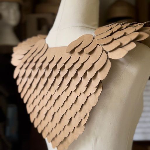 a mannequin with paper wings on it's chest and collar made out of cardboard