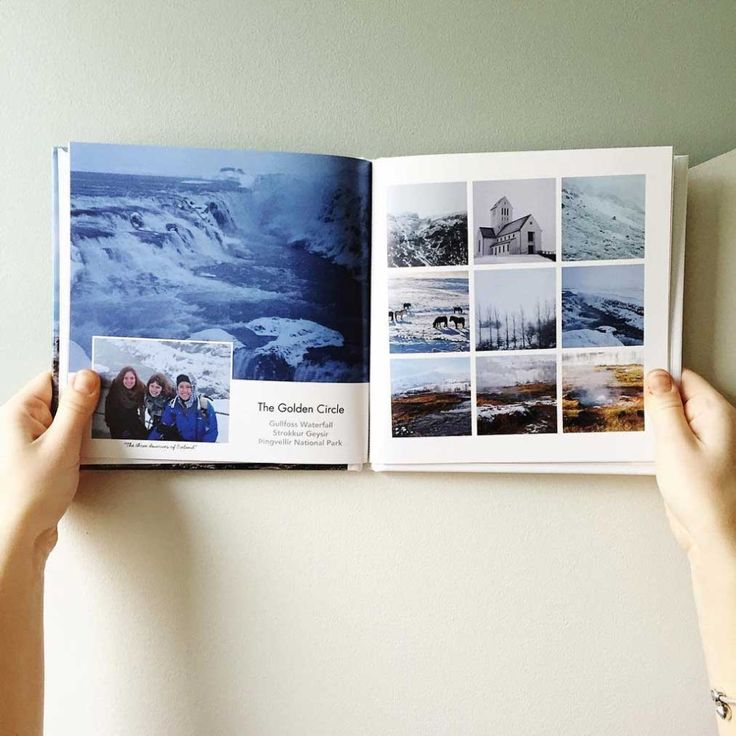 two hands are holding an open photo book