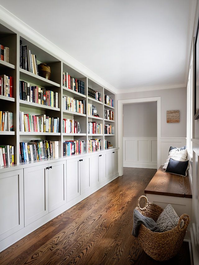 the bookshelves in this room are filled with many different types of books and have baskets on them