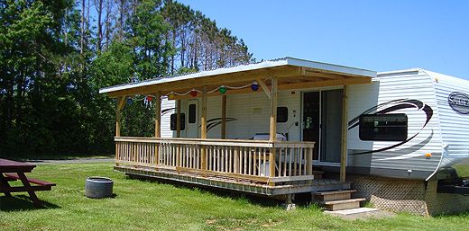 an rv parked in the grass next to a picnic table